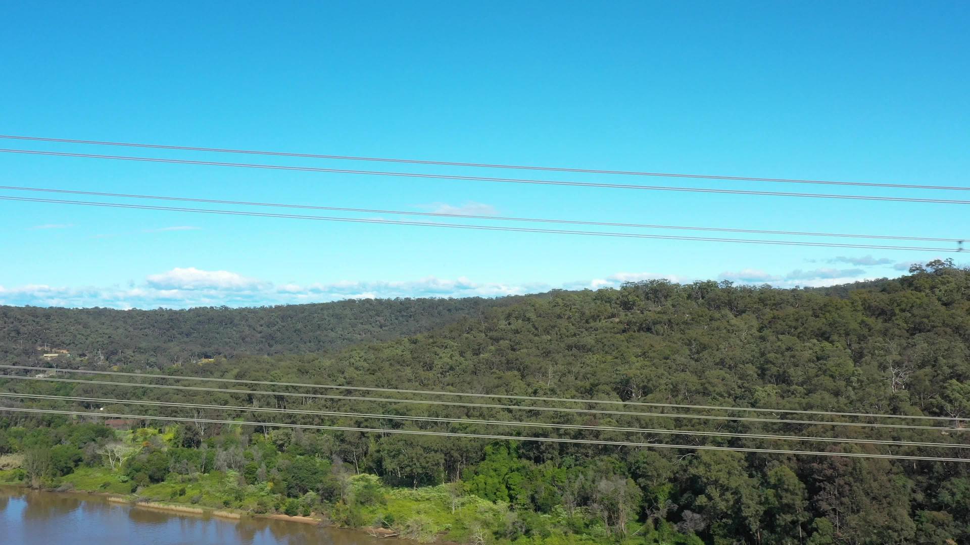 输电塔电力线横跨河流的空中飞行视频视频的预览图