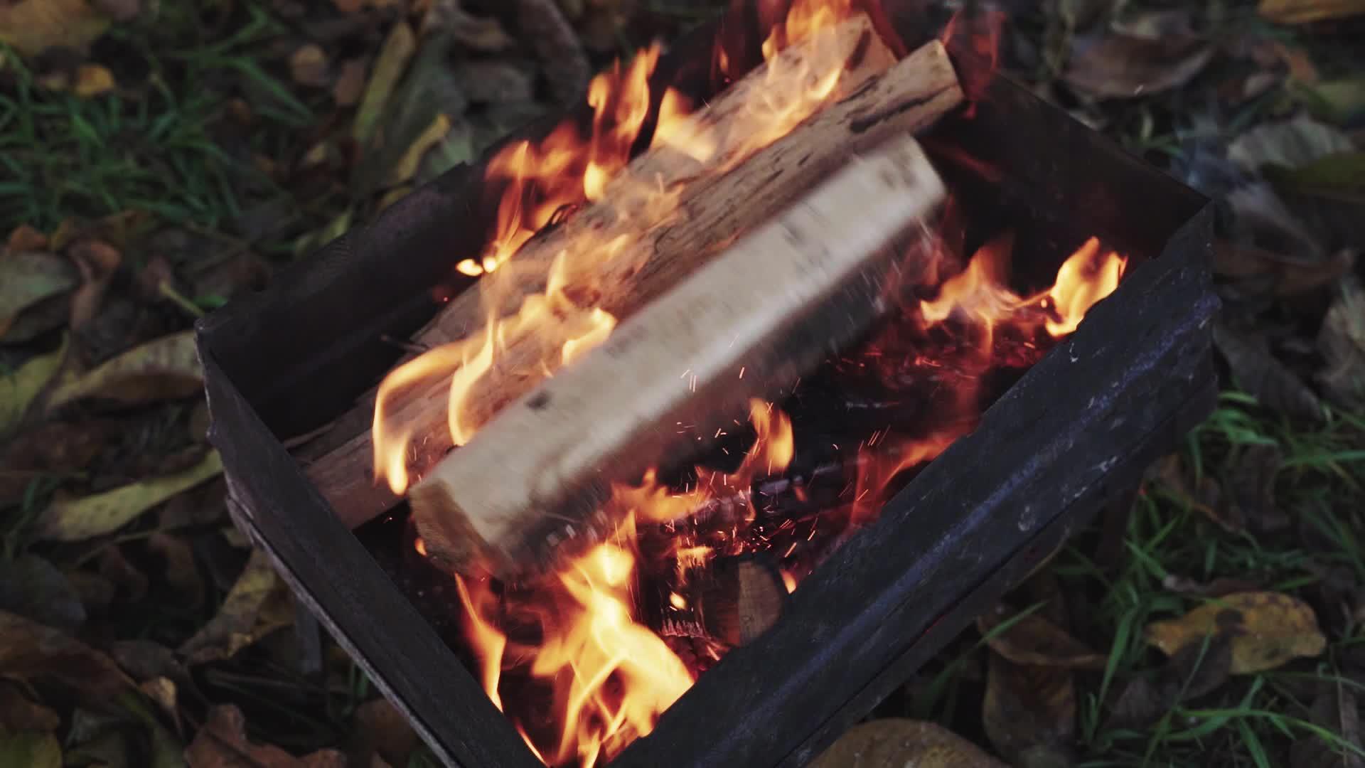 把柴火扔进烧烤炉的火里视频的预览图