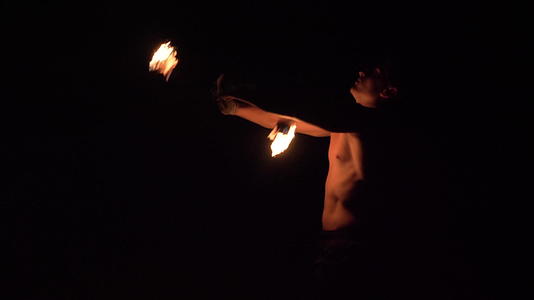 肌肉男用铁链旋转两个火球进行消防表演视频的预览图