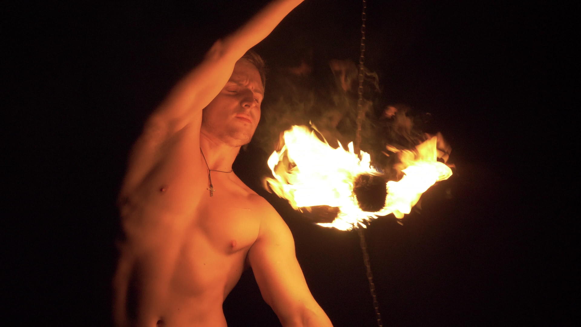 肌肉男正在表演消防表演两个火球在链条上旋转视频的预览图