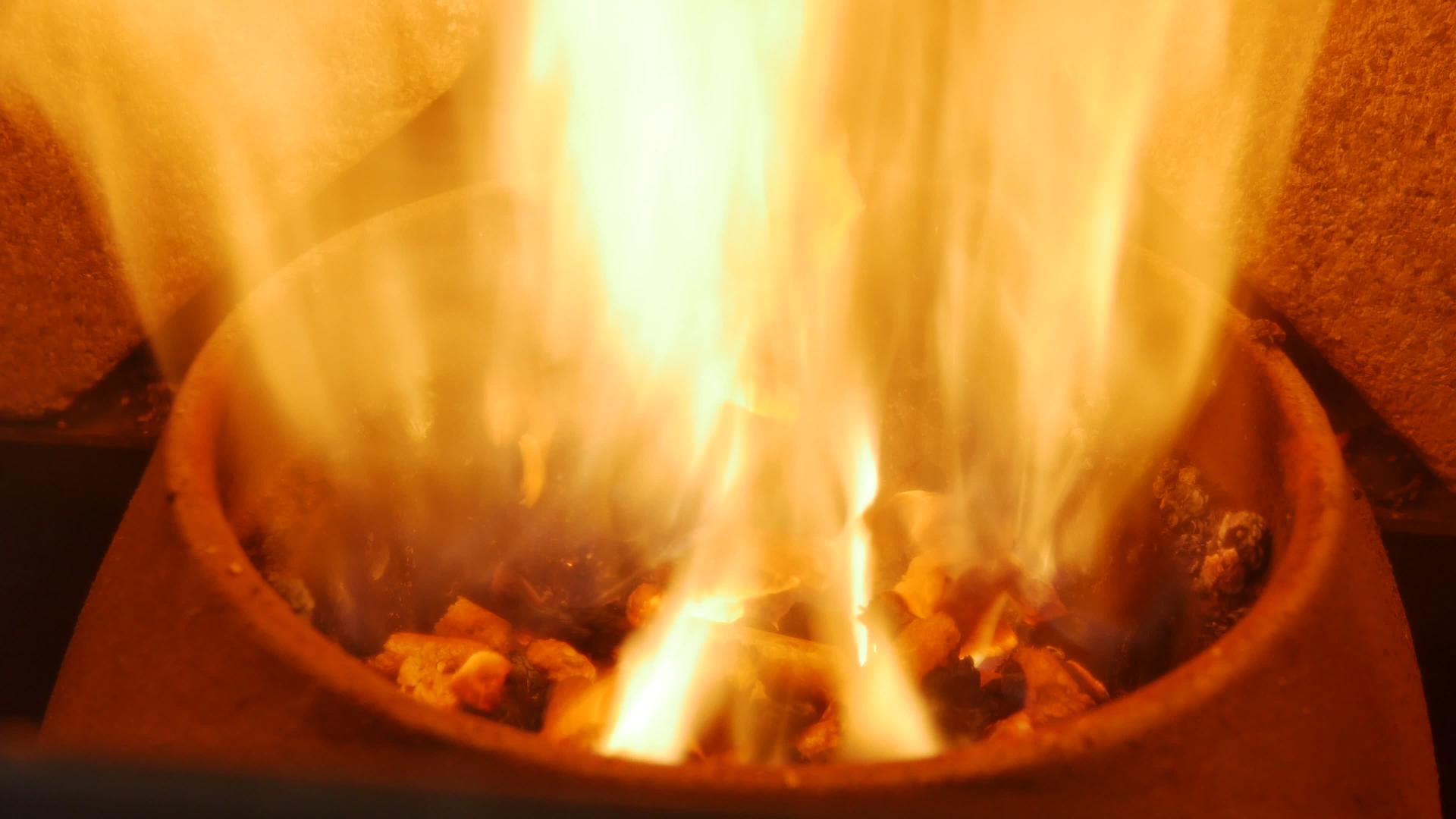 黄色和橙色的火焰在现代颗粒炉中燃烧火焰视频的预览图