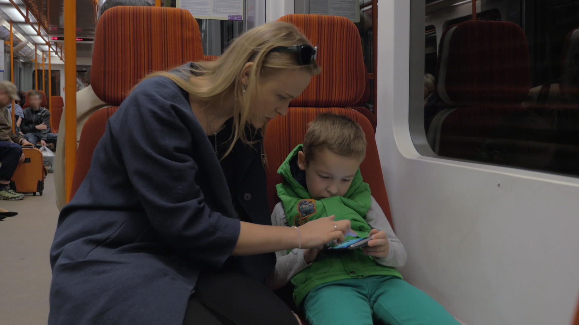 儿童和母亲在地铁列车上使用移动电话视频的预览图