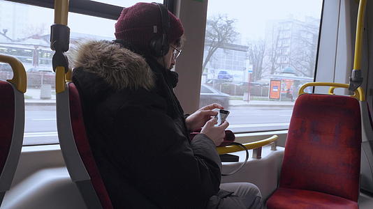听音乐的人在公共交通中使用智能手机视频的预览图