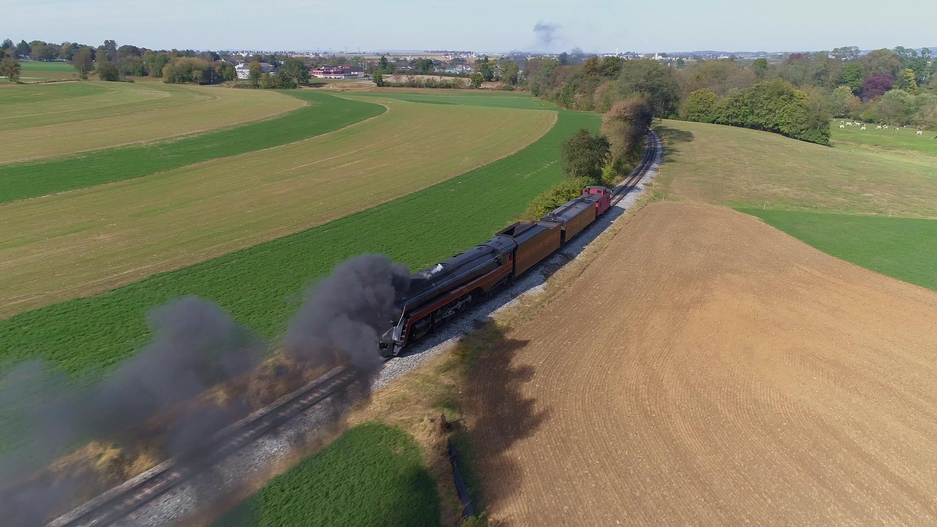 在农村喷发黑烟和蒸汽的恢复蒸汽机后面的古董空气景观视频的预览图