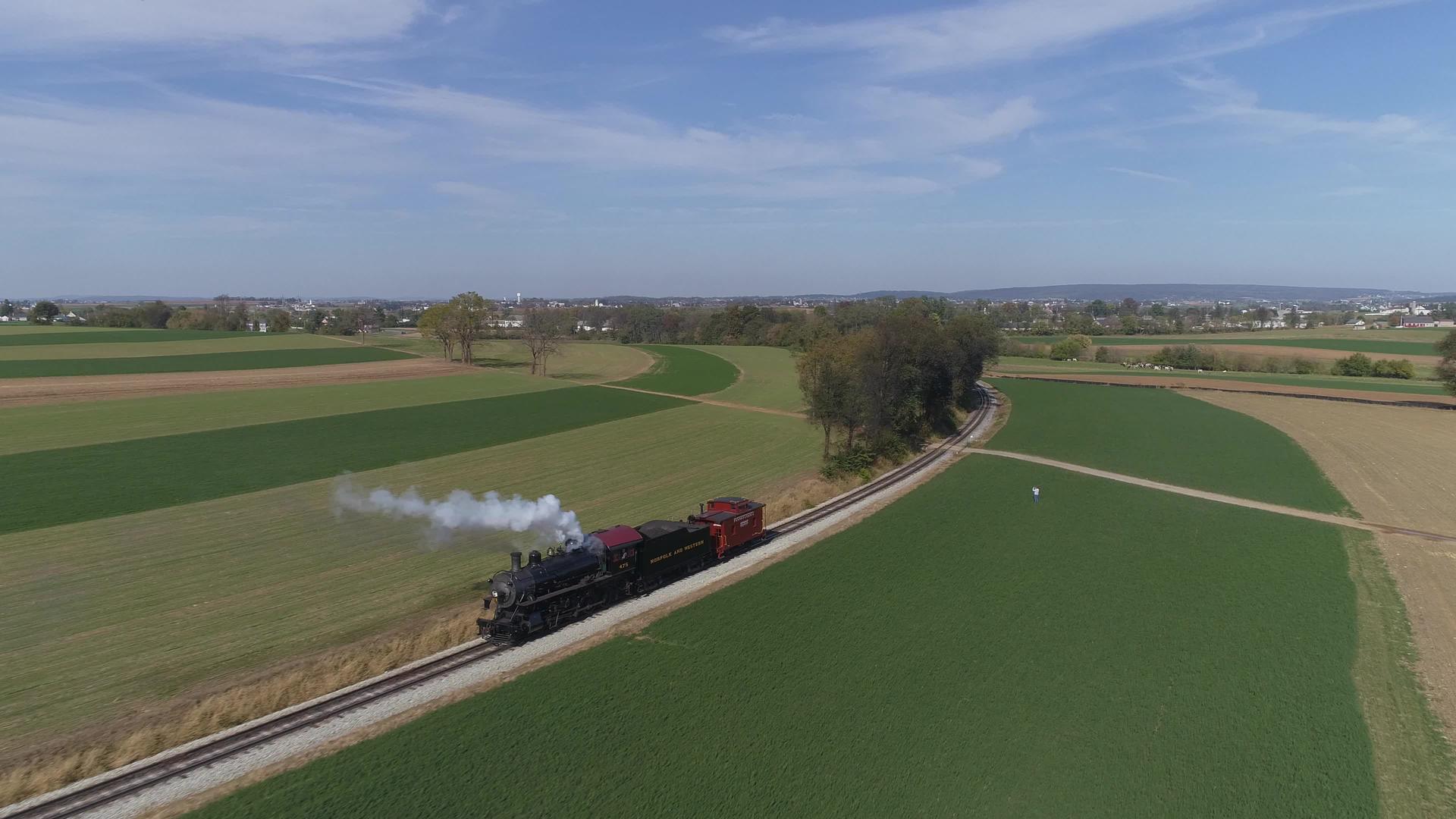 在农村喷发黑烟和蒸汽的恢复蒸汽机后面的古董空气景观视频的预览图