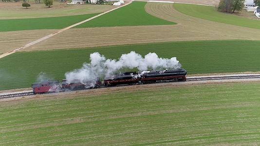 古董的空中侧视角恢复了蒸汽机车在乡村旅行时吹黑白烟视频的预览图