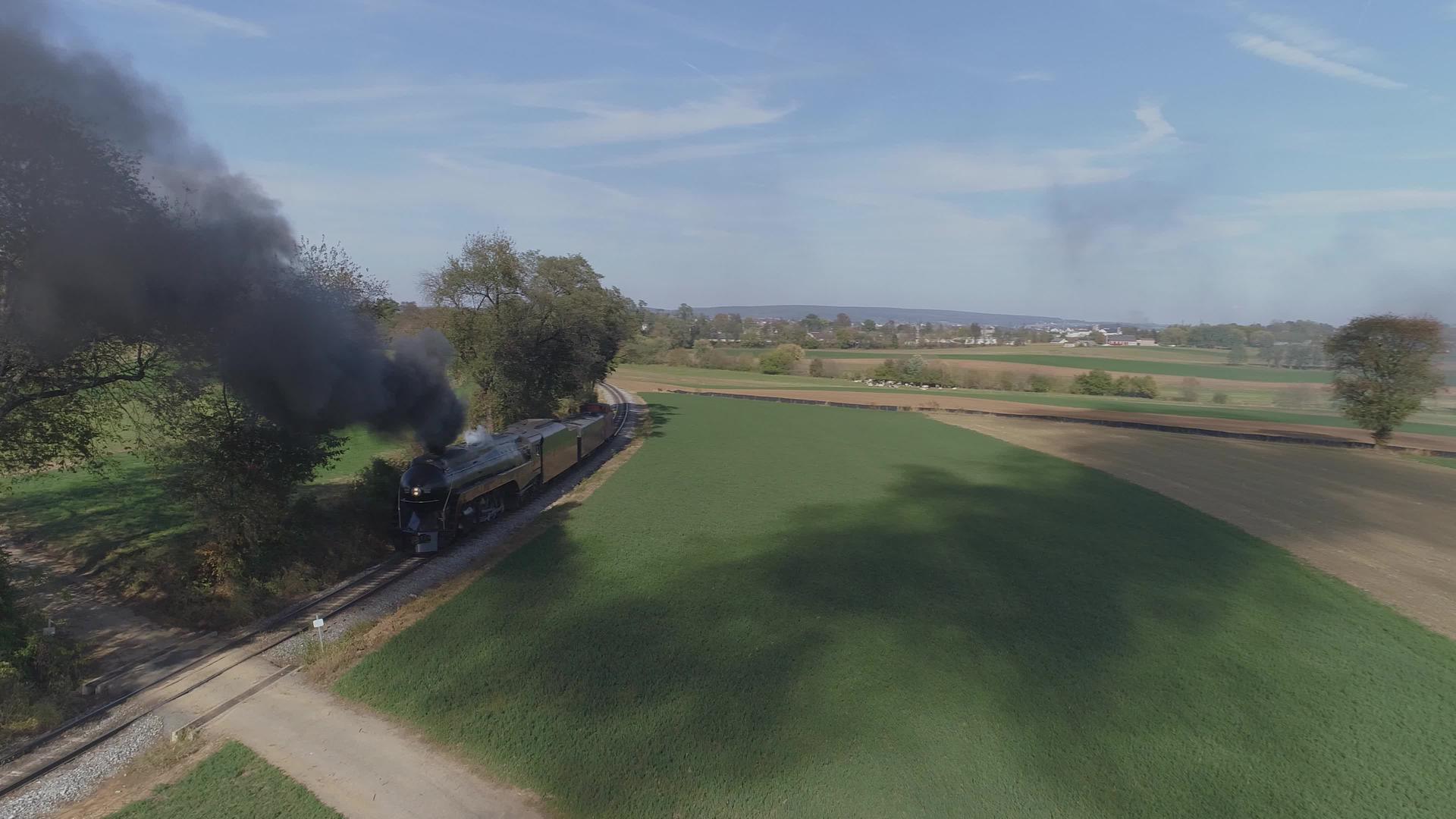 头部在田间吹黑烟的黑烟和古董恢复蒸汽机的空气景观视频的预览图