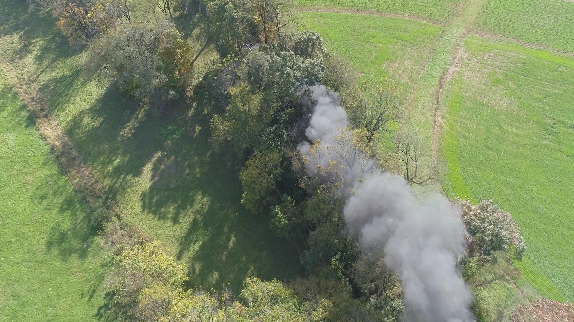 古老的恢复蒸汽发动机在空中观光它在烟雾和蒸汽的树上飞舞视频的预览图