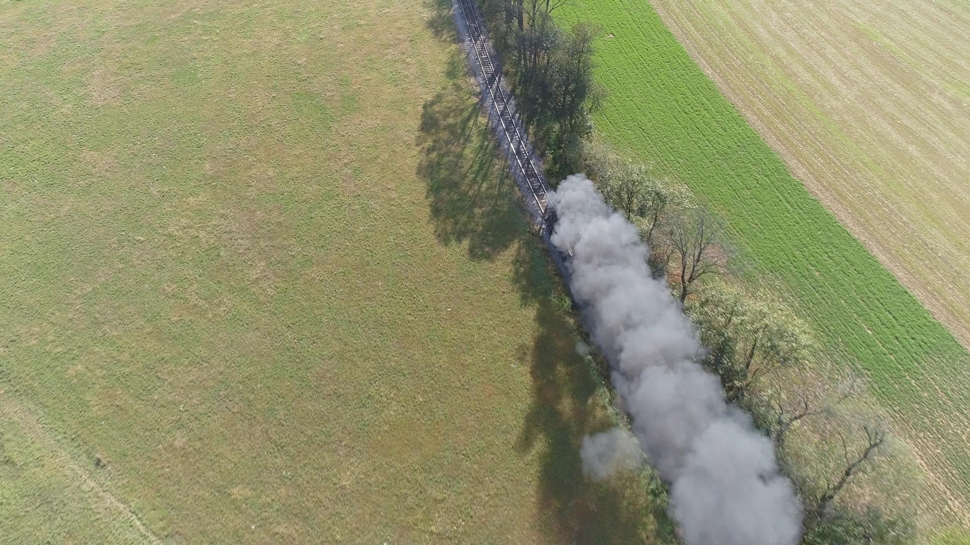 古老的恢复蒸汽发动机在空中观光它在烟雾和蒸汽的树上飞舞视频的预览图