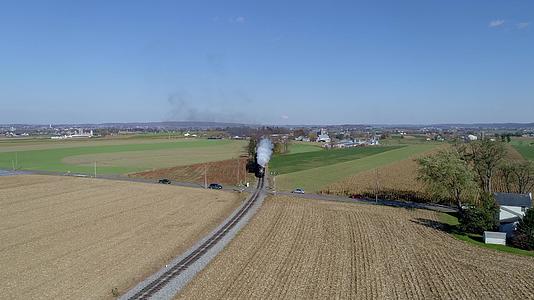 从空中俯瞰一辆经过修复的古董蒸汽机车在乡间行驶视频的预览图
