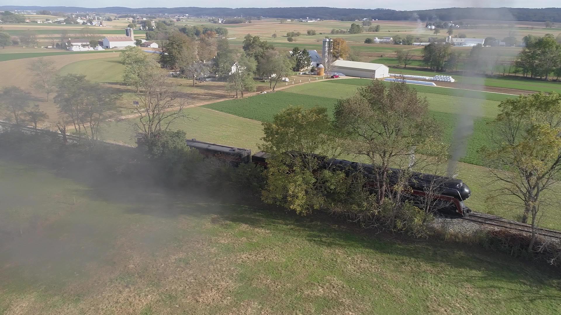 一辆修复的古董蒸汽机车的空中侧视图停在乡村吹着吹着视频的预览图