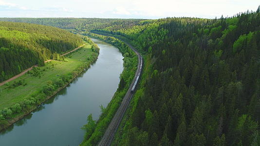 向前和向下飞越火车河流和绿林空中视频的预览图