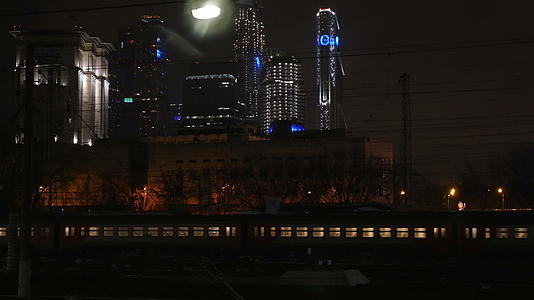 夜间通过城市的公共汽车和火车视频的预览图