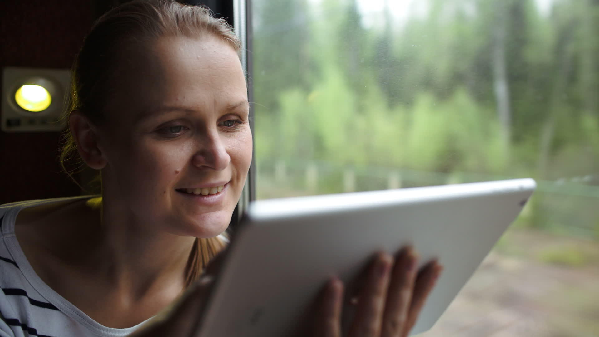 坐在火车窗边的年轻女性使用触摸板视频的预览图