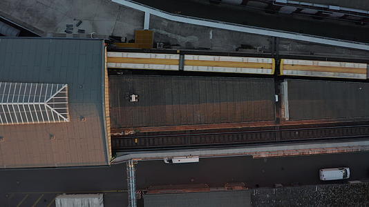 黄色列车从空中鸟类进入伯林高地地面的地铁站视频的预览图