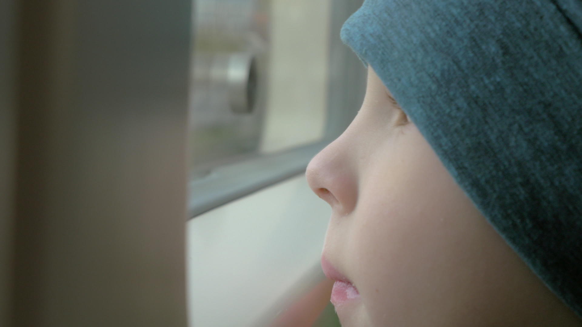 在火车上一个戴着帽子的小男孩看着窗外视频的预览图