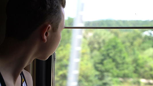 青少年乘火车到外面看窗外视频的预览图