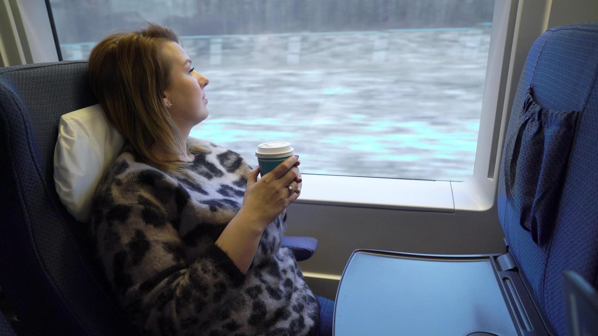 在火车上喝茶或咖啡的年轻女性视频的预览图