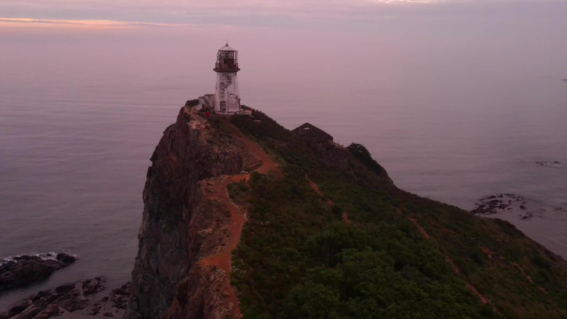 从上面的风景飞过鲁德尼·勃里纳灯塔在黎明的蓝色海洋中视频的预览图