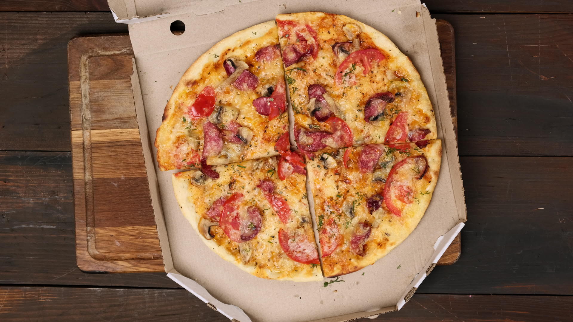 用香肠、西红柿和奶酪在白纸箱里烤比萨饼视频的预览图