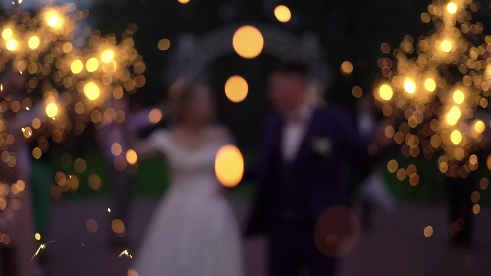 人们在街上点燃火花庆祝婚礼的浪漫之夜或夜晚视频的预览图