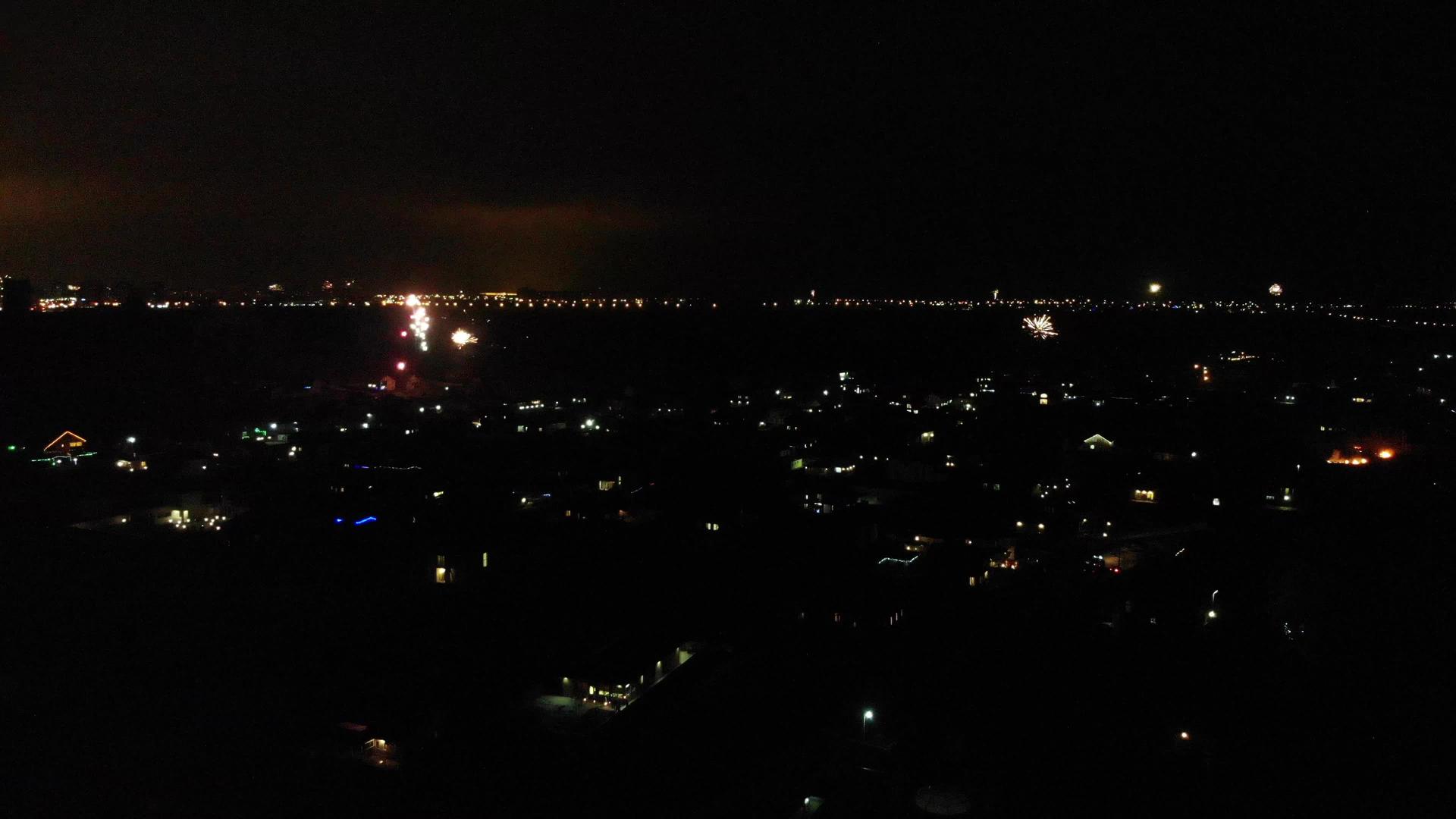 在新年的烟花中夜晚城市的空中测量消防车向城市开着闪光灯视频的预览图