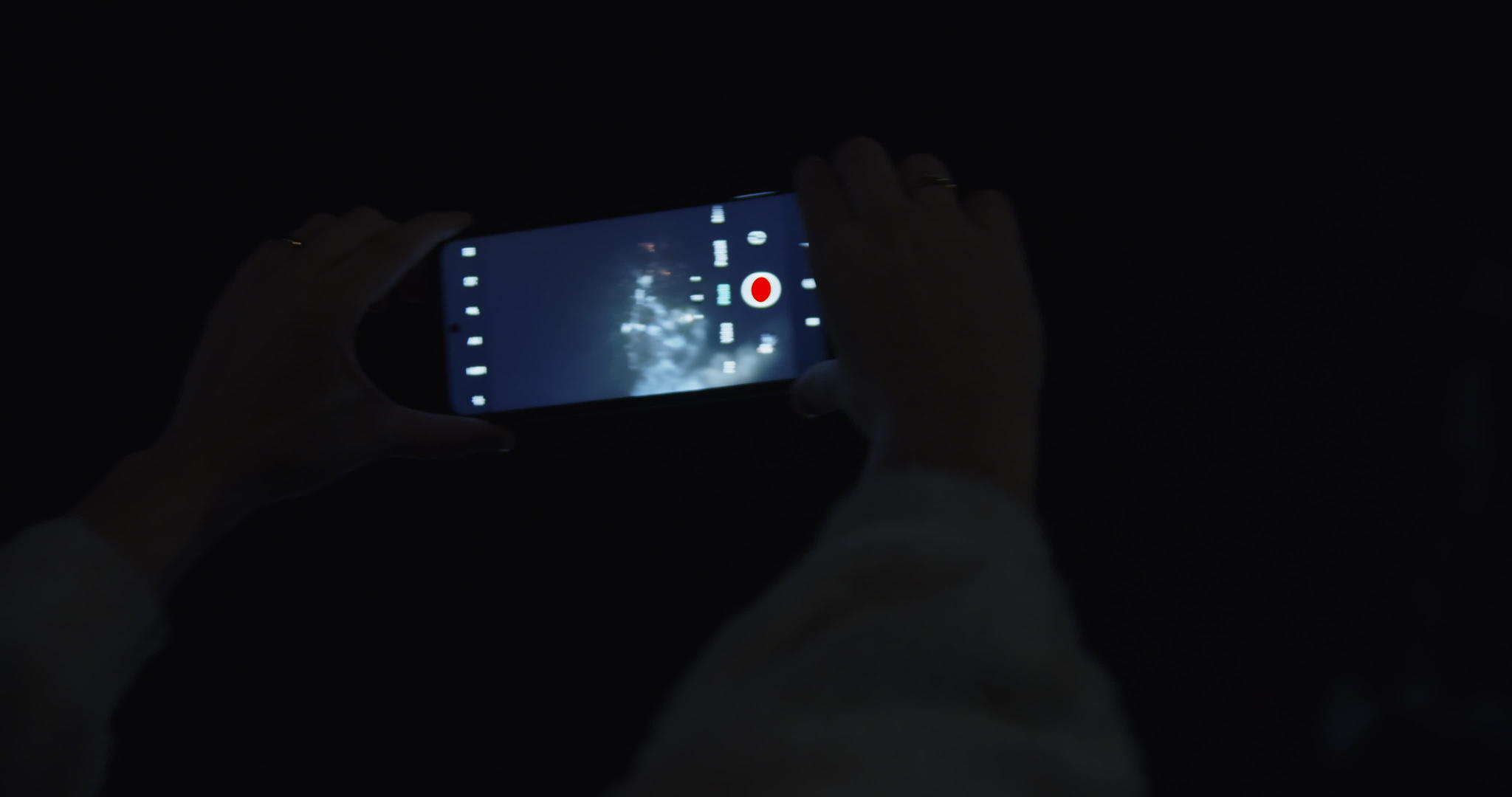 一个女人在晚上捕捉烟火视频的预览图
