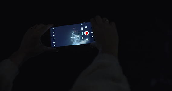一个女人在晚上捕捉烟火视频的预览图