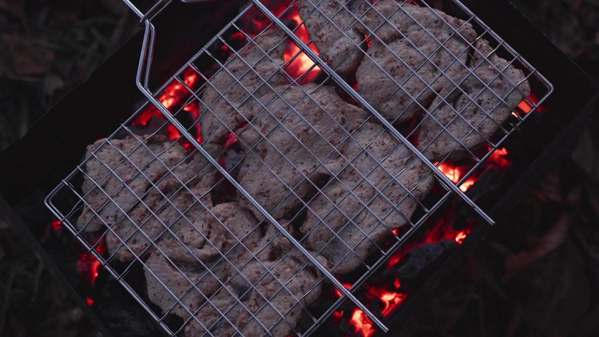 在烧烤木炭的网格中煮猪肉视频的预览图