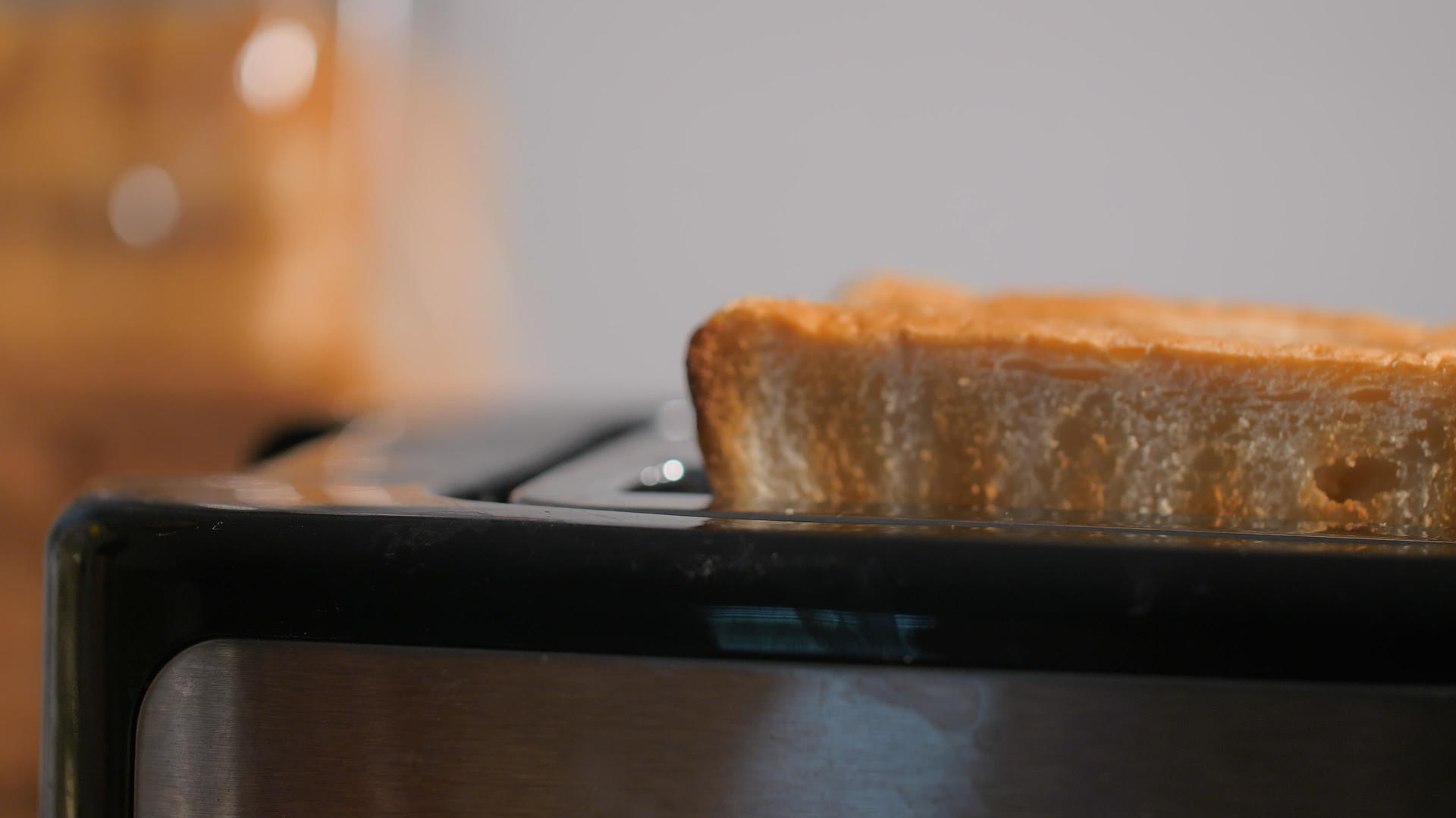 在厨房吃早餐时女人从面包机里拿出面包吃视频的预览图