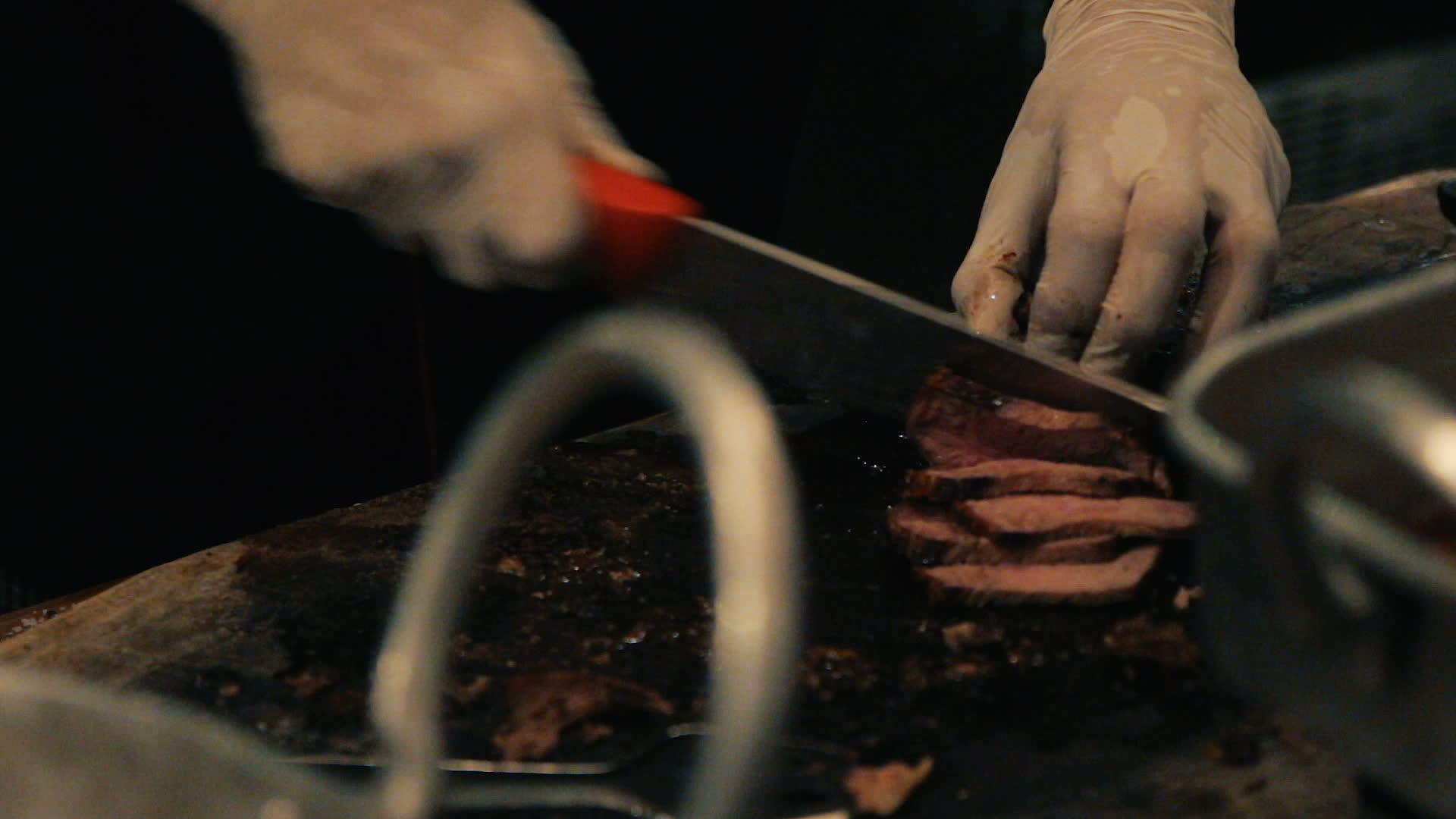 双手紧握在砧板上的烟熏牛肉迅速将煮熟的牛肉切成薄片视频的预览图