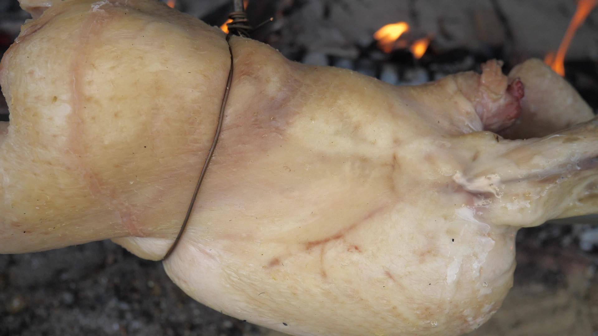 在与传统烤鸡的园艺聚会上鸡皮放在火上方视频的预览图