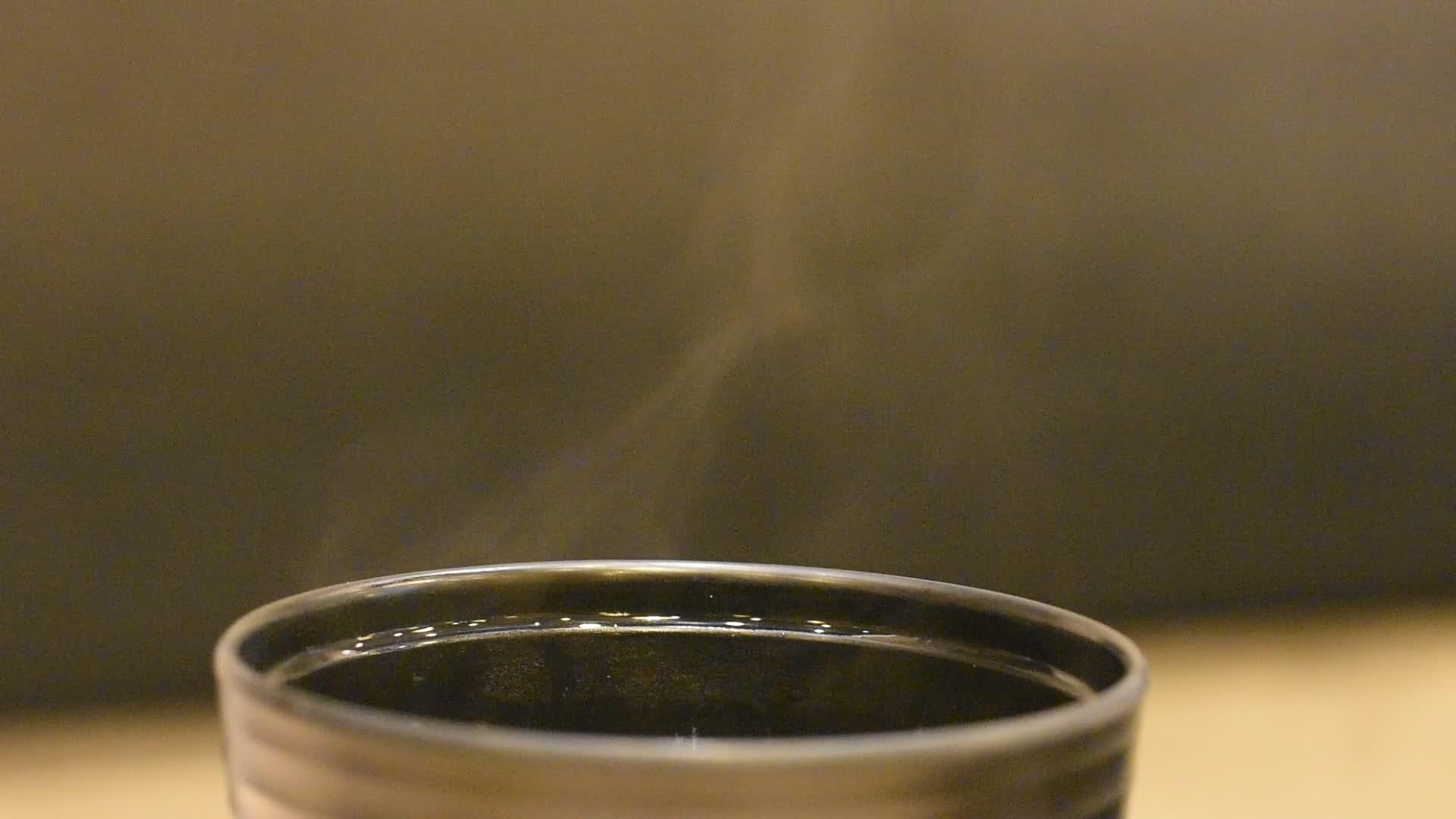 从杯子的黑汤热中抽烟视频的预览图