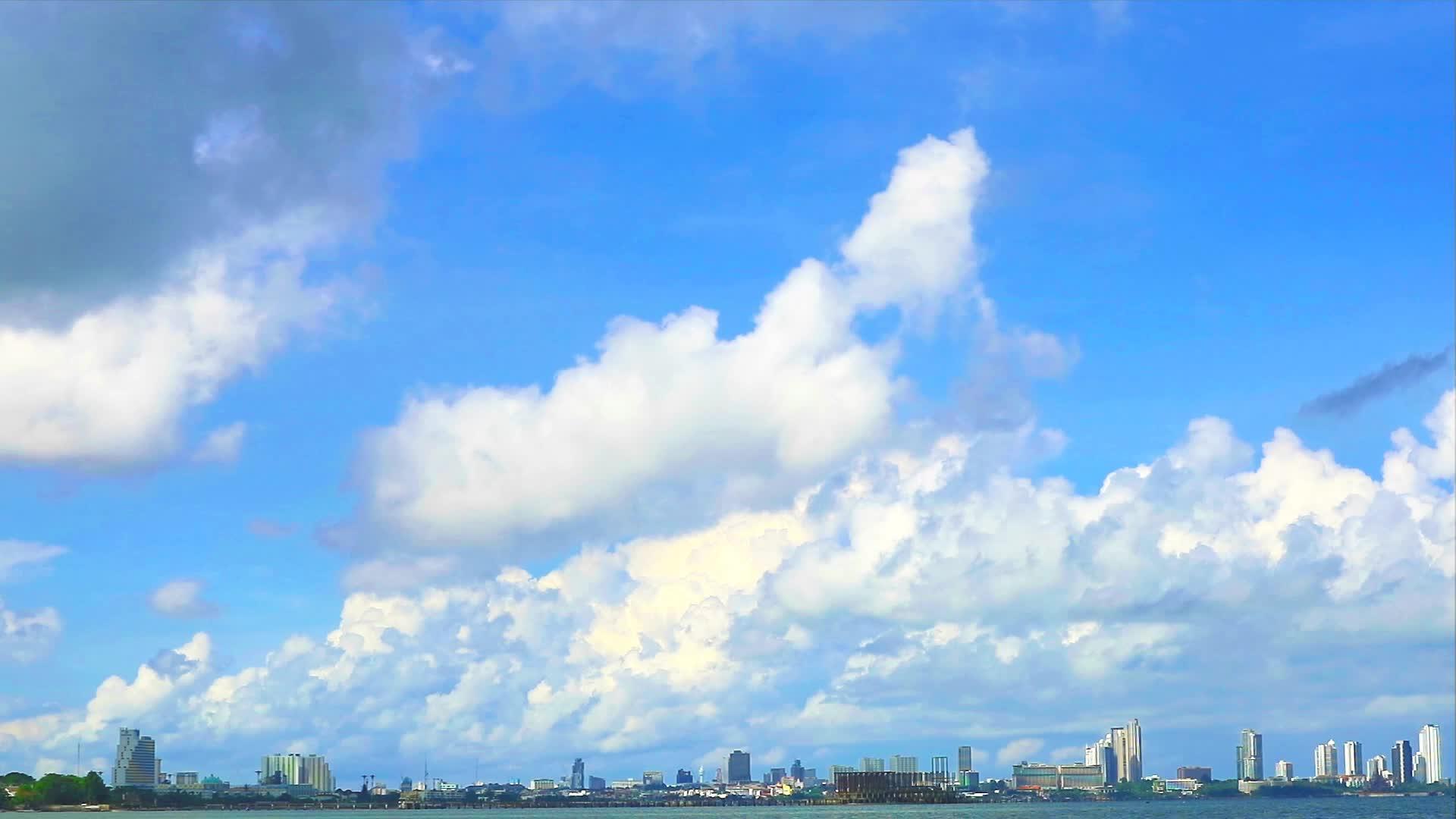 在雨季和冬季繁忙的云彩和蓝天横跨大海和城市视频的预览图