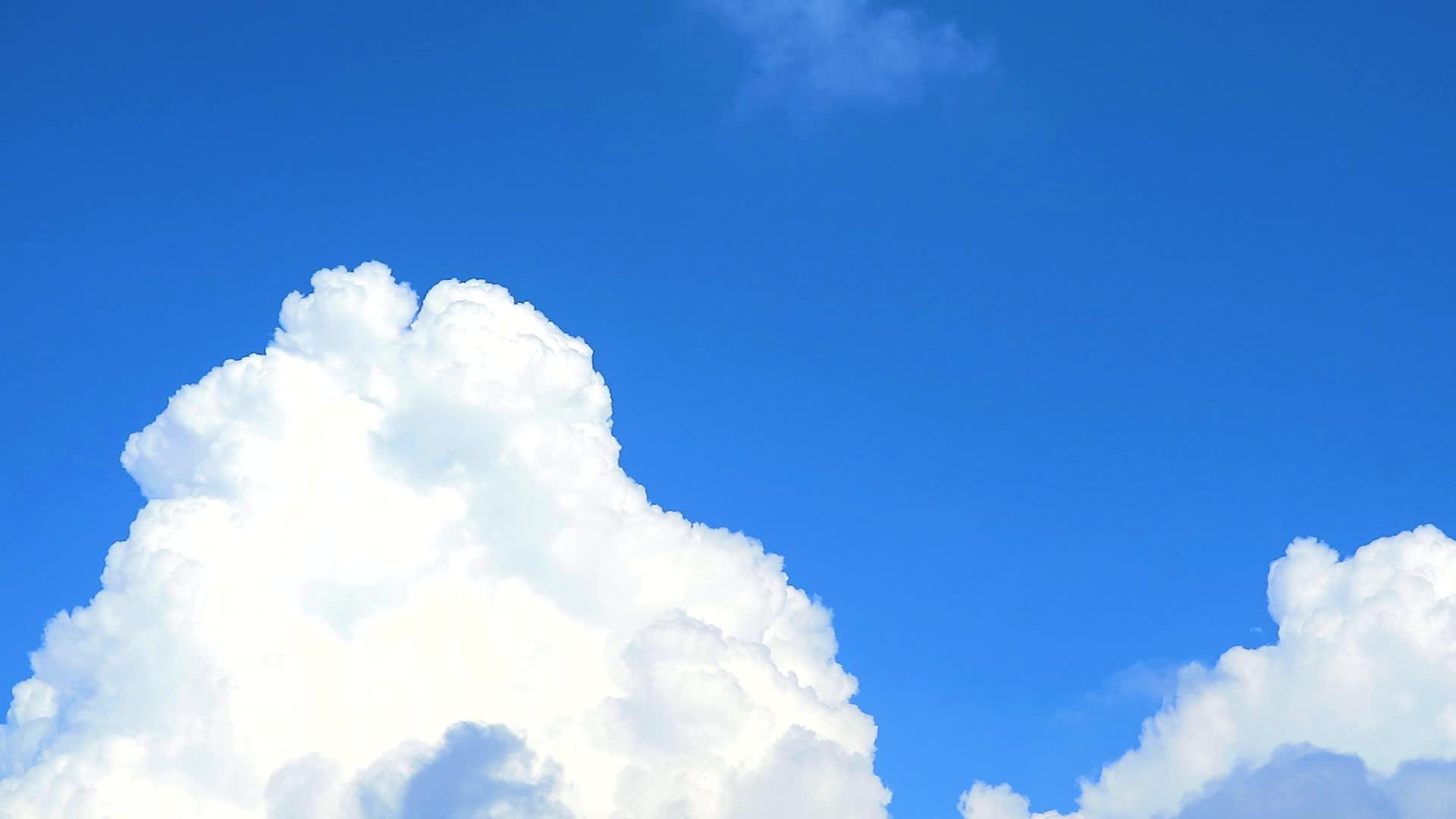 美丽的纯白云在蓝天的背景下移动视频的预览图