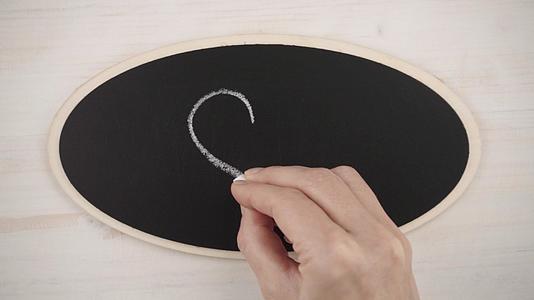 在黑板上画一支白色粉笔的手工心脏看着平平面视频的预览图