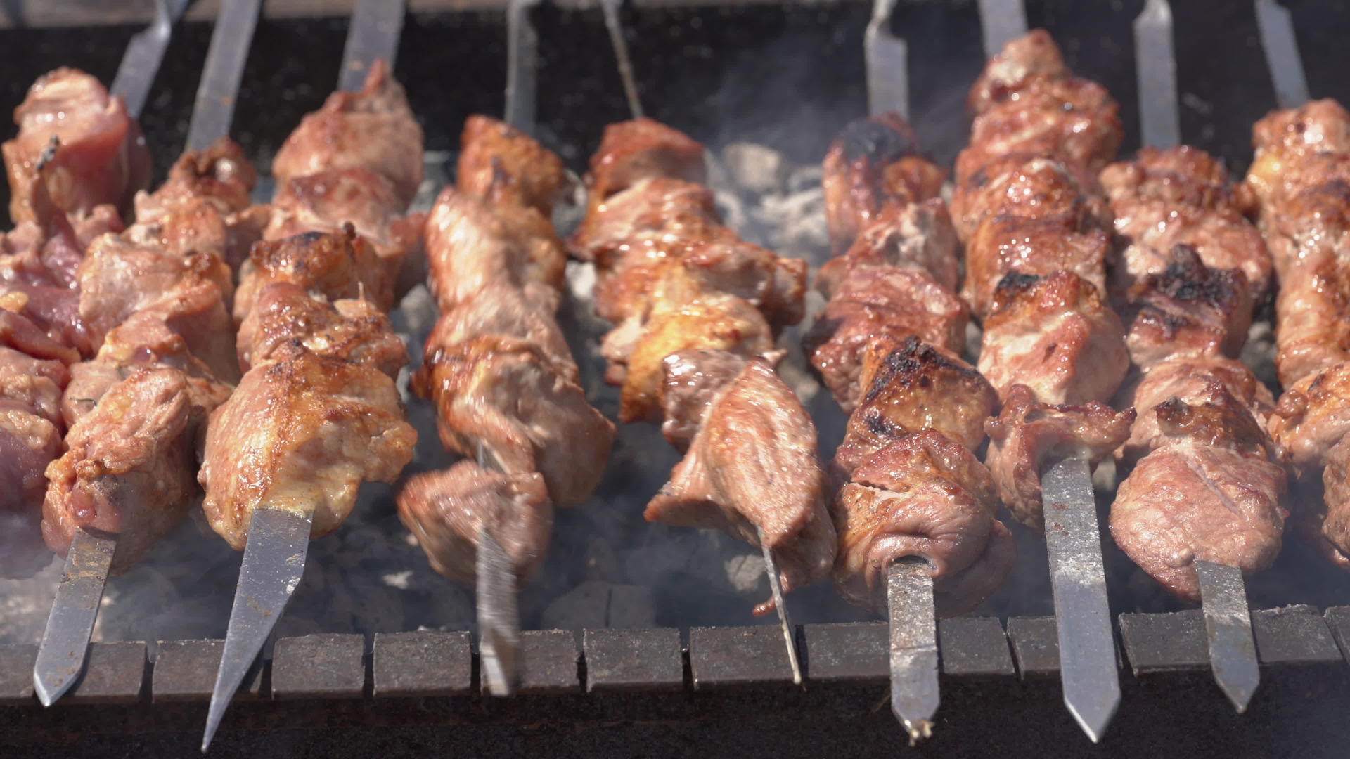 烤猪肉串在木炭烤架上用金属串烹饪视频的预览图