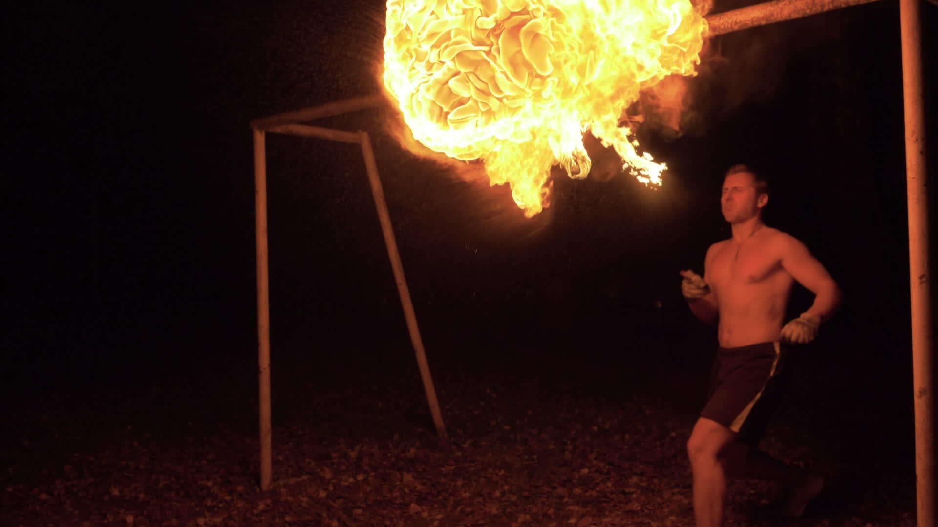 肌肉发达的白人在火炬上喷洒煤油从嘴里喷出火焰视频的预览图