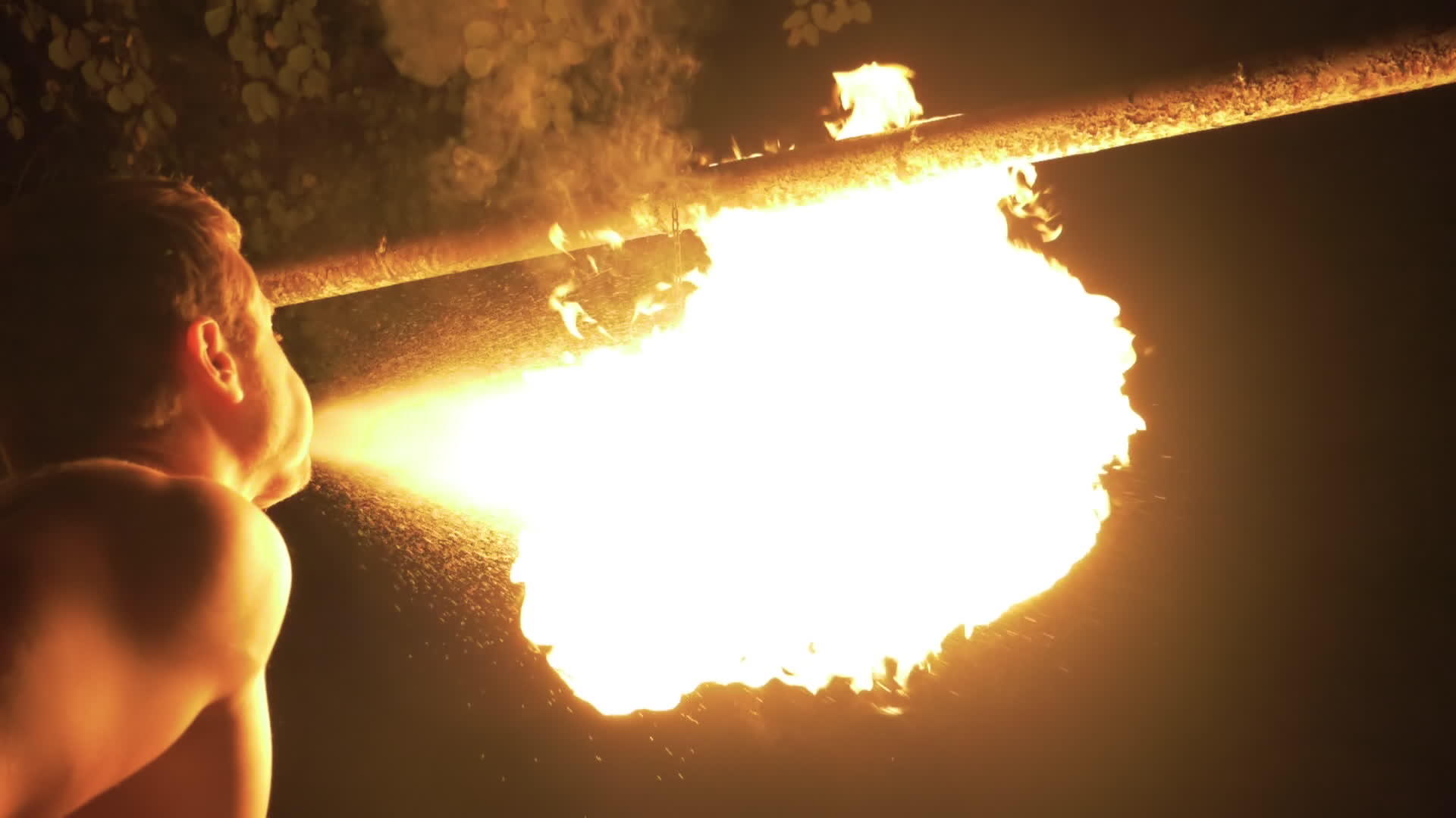 男子在火炬和爆燃的火焰中喷洒汽油展示慢动作视频的预览图