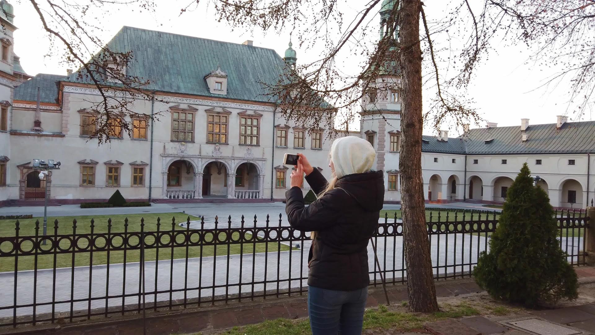 女游客在广场上拍下了旧宫殿的照片视频的预览图