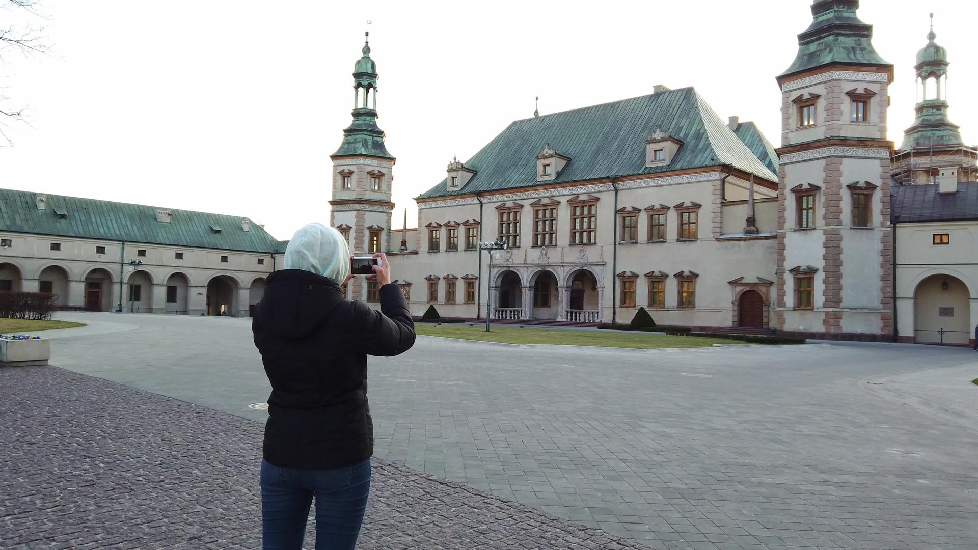 女游客在广场上拍摄宫殿的旧照片视频的预览图