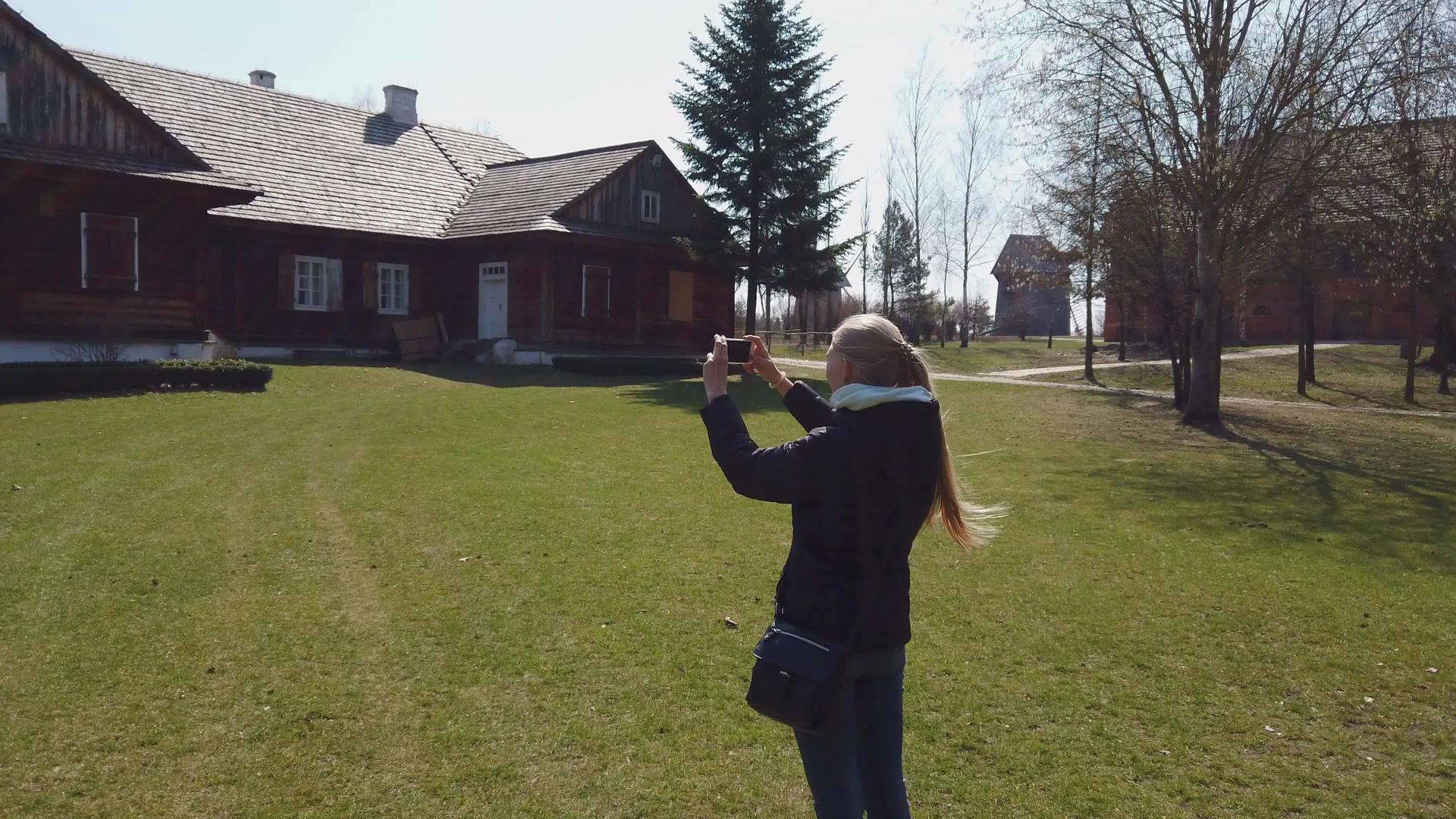 女游客在一个旧欧洲村庄拍摄木屋照片视频的预览图