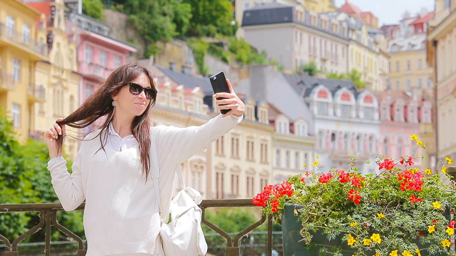 年轻女性在欧洲城市拍摄自画像背景美丽的房子白人游客视频的预览图