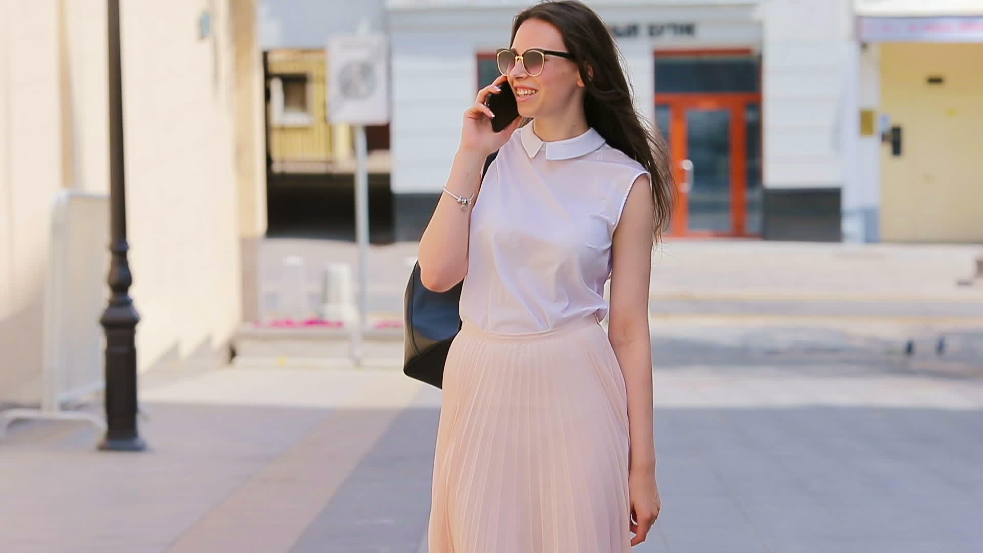 这个年轻的白人女孩在欧洲城市的户外用她的智能手机在街上说话视频的预览图