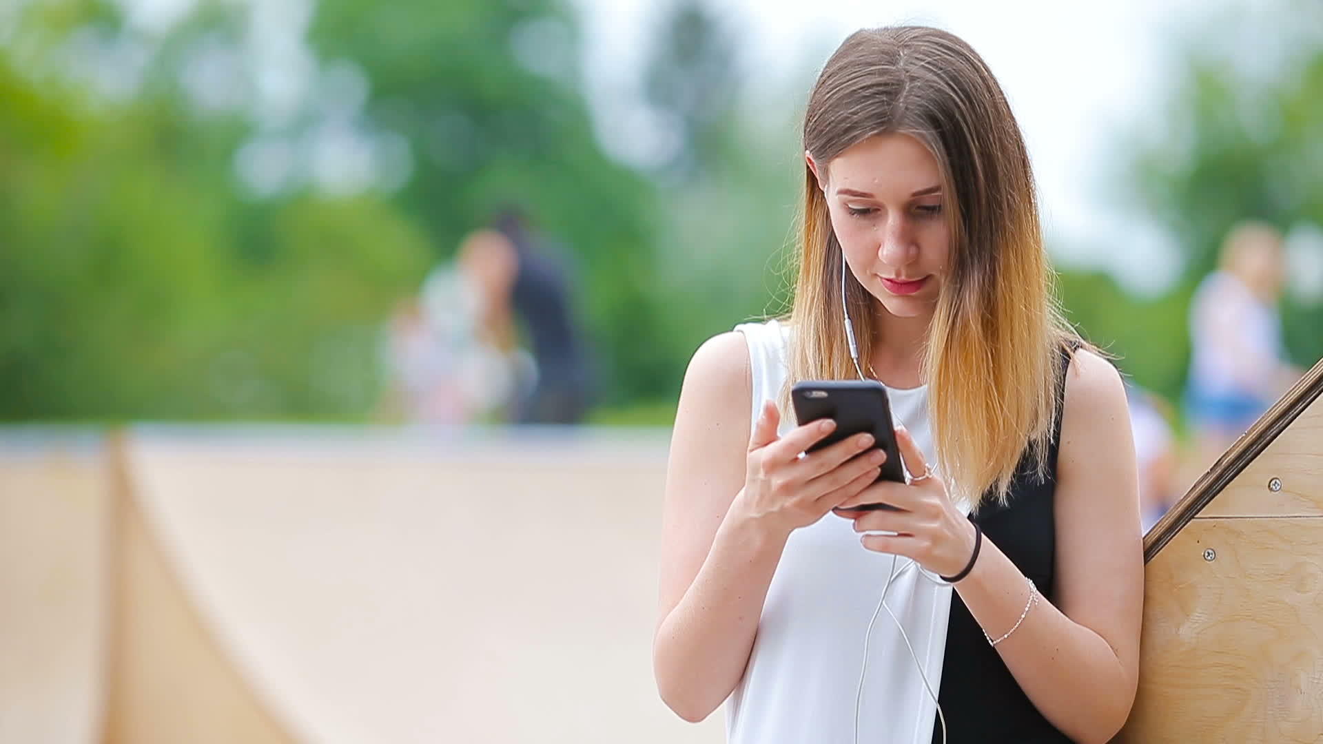 年轻的白人妇女在欧洲城市发送信息在户外听音乐戴太阳镜视频的预览图