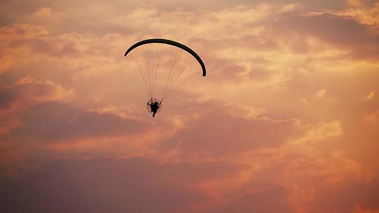 日落天空背景下的月光滑翔伞视频的预览图