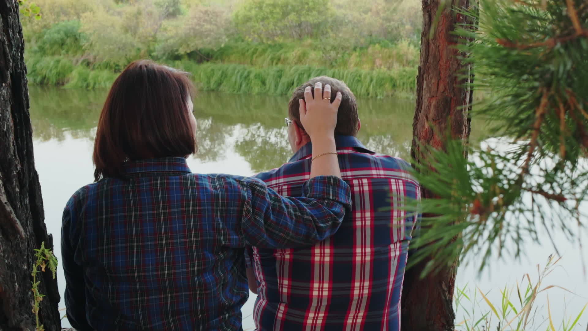 这对恩爱的夫妇在松树林的河岸上拥抱女人在森林河岸上拥抱女人视频的预览图