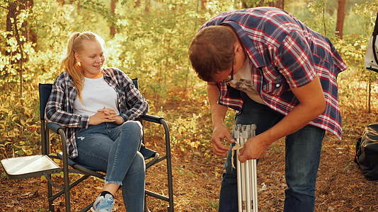 父亲和女儿在秋天的森林里野餐男人在农村野餐视频的预览图