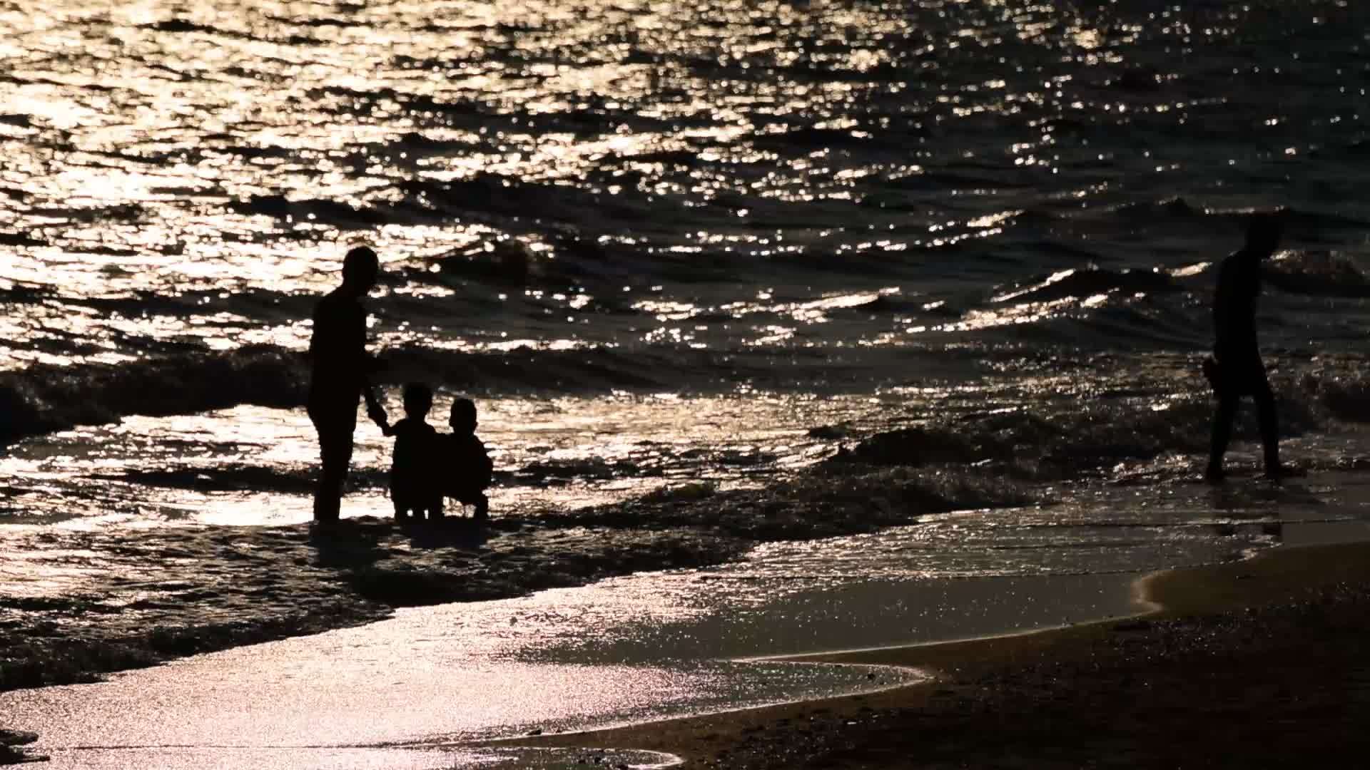 家庭在海滩上快乐的光影视频的预览图