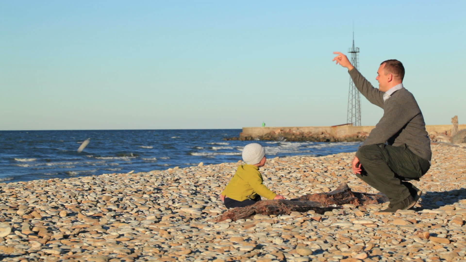 父亲和儿子在石滩上玩耍视频的预览图